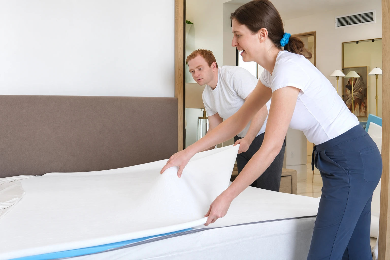 A couple placing a foam insert into their Comfy Couples topper